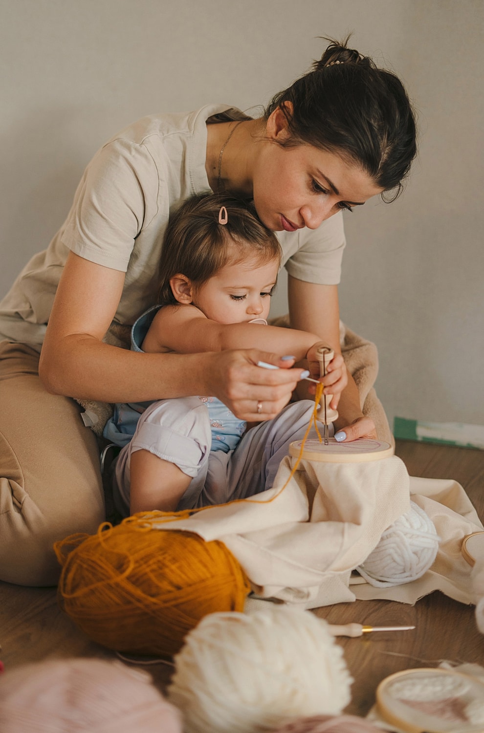 Mother and child crafting together with yarn.