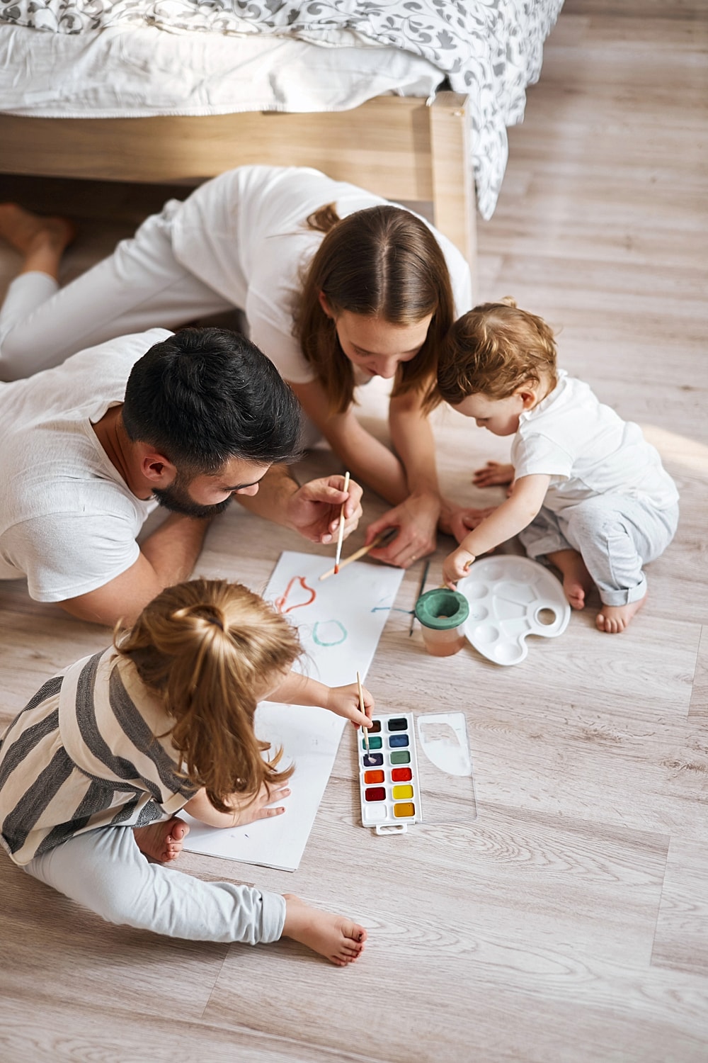 Family painting together on the floor.